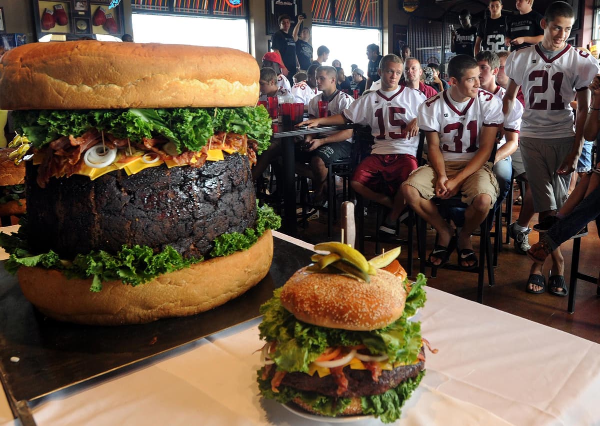 El miembro del equipo de fútbol de South Anderson High School intenta comer su parte de 300 libras de hamburguesa en Mallie's Sports Bar and Grill. (Foto: Dave Chapman)